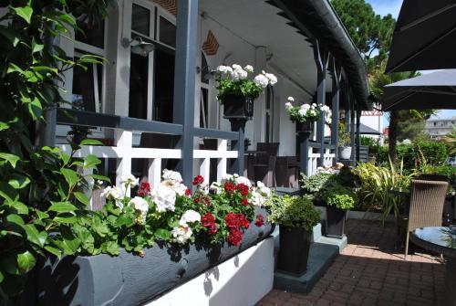 une terrasse couverte avec des fleurs et des plantes. dans l'établissement Hotel Ty Gwenn La Baule, à La Baule