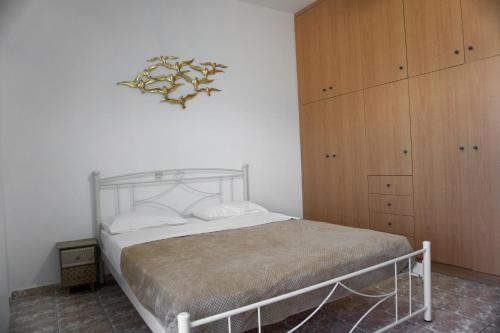 Blue Star Sea Apartment في أذيليانوس كامبوس: غرفة نوم بسرير وخزانة خشبية