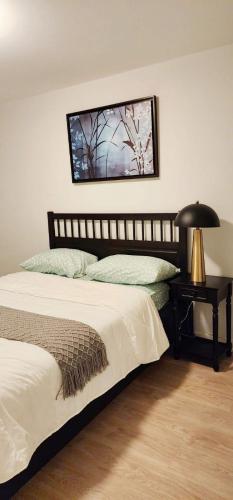 a bedroom with two beds and a table with a lamp at Sunset Place in Ottawa