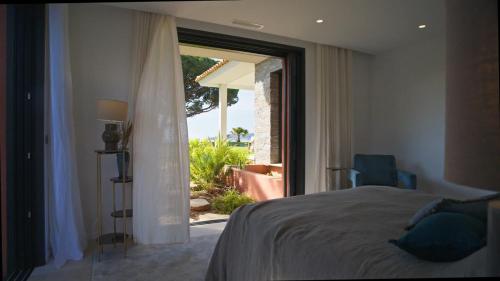 a bedroom with a bed and a large window at Villa Alda in Saint-Tropez