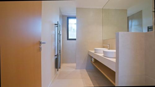 La salle de bains est pourvue de 2 lavabos et d'un miroir. dans l'établissement Villa Alda, à Saint-Tropez