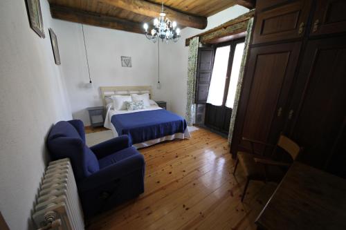 1 dormitorio con cama, sofá y lámpara de araña en Casa Magueto en Toreno