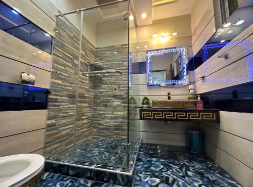 a bathroom with a shower and a toilet and a sink at Luxury Penthouse Bahria Town in Lahore