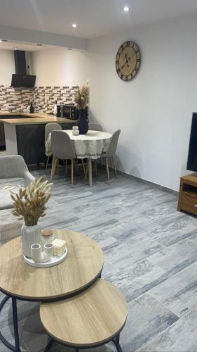 un salon avec des tables et une horloge au mur dans l'établissement Appartement neuf (T3), à Marseille