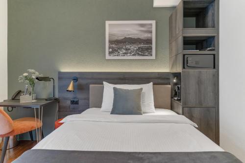 1 dormitorio con 1 cama grande, escritorio y silla en Waldstätterhof Swiss Quality Hotel, en Lucerna