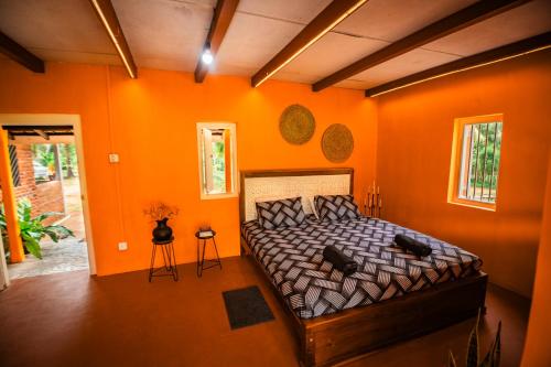 a bedroom with orange walls and a bed in a room at Chimney House by Serendia in Makandura