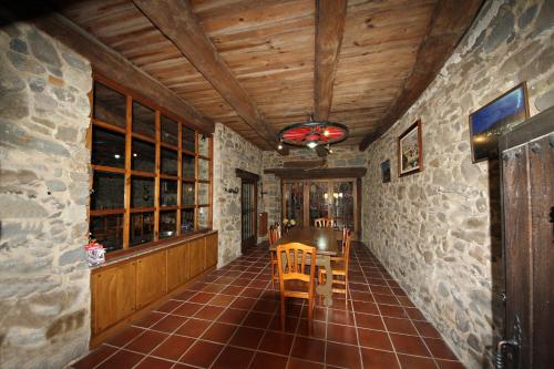 comedor con mesa y pared de piedra en Casa Magueto en Toreno