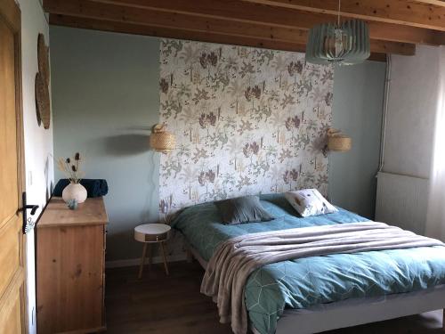 a bedroom with a bed with a floral wall at La Bastilac chambre Nature in Garganvillar