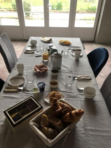 a table with a plate of food on it at La Bastilac chambre Nature in Garganvillar