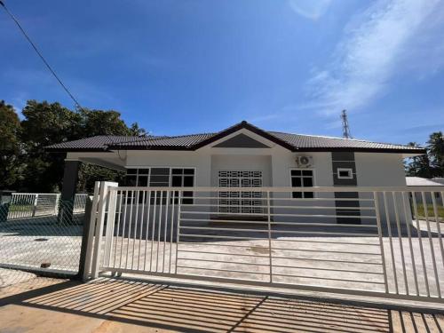 a house with a gate in front of it at Homestay Tengku Arif Batu Rakit in Kuala Terengganu