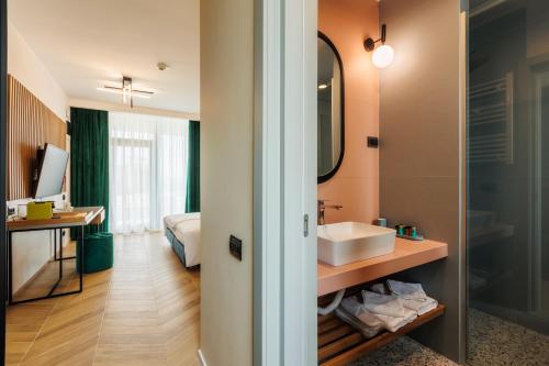 y baño con lavabo y espejo. en Hypnose Resort en Vadu