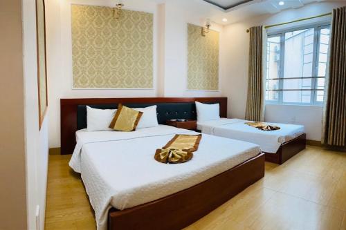 a hotel room with two beds and a window at Victoria hotel in Ha Long