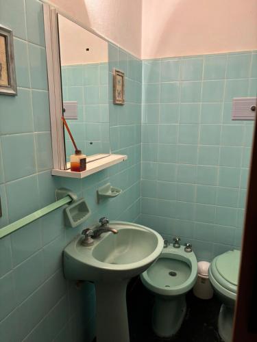 Baño azul con lavabo y aseo en Hotel El pescador en Salvador María