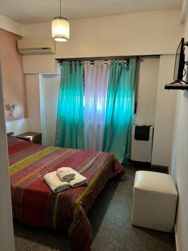 1 dormitorio con 1 cama con cortinas verdes en Hotel El pescador en Salvador María