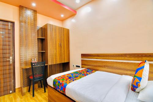 a bedroom with a bed and a chair in it at HOTEL KANAN INN in kolkata