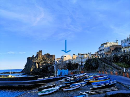 a bunch of boats are lined up in a harbor at The sea you can feel in Aci Castello