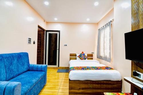 a bedroom with a bed and a blue couch at HOTEL KANAN INN in kolkata
