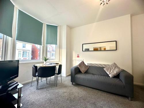a living room with a couch and a table at Sienna Family Holiday Apartments in Blackpool