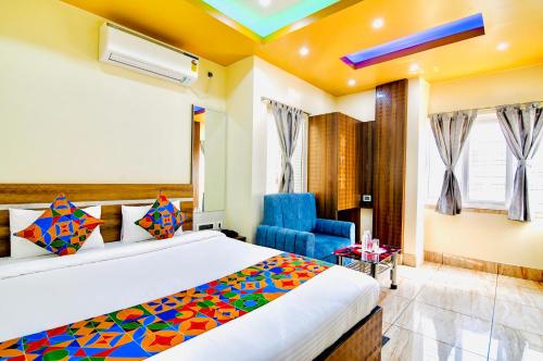 um quarto com uma cama e uma cadeira azul em HOTEL KANAN INN em kolkata
