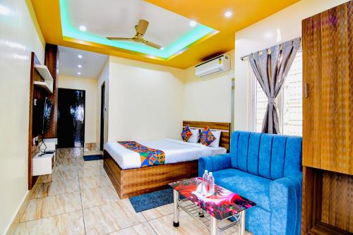 a hotel room with a bed and a blue couch at HOTEL KANAN INN in kolkata