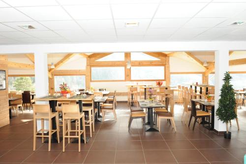 une salle à manger avec tables, chaises et fenêtres dans l'établissement Hameau 5 201a - SPA & PISCINE studio 2 pers, à Orelle