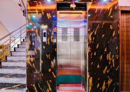 a glass elevator door in a building with stairs at HOTEL KANAN INN in kolkata