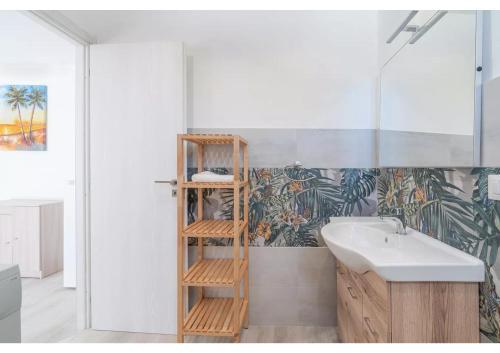 シラクーサにあるLa Caretta di Ogninaの洗面台の横に木製の棚があるバスルーム