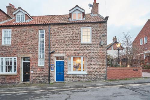 een stenen huis met een blauwe deur op een straat bij Cobble Cottage in Whitby
