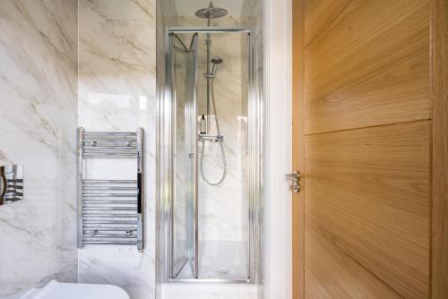 a bathroom with a shower and a glass door at Charles Hope Staines Riverside in Staines