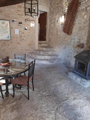 uma sala de pedra com uma mesa e um fogão em Molí d'en Pi em Morella