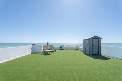 a balcony with green grass and a small shed at Casacamer N in Sagunto