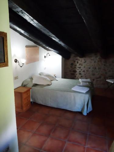 um quarto com uma cama branca e uma parede de tijolos em Molí d'en Pi em Morella