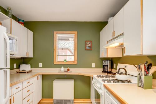 a kitchen with white cabinets and a green wall at Family Cabin with Private Dock on Caribou Lake! in Lutsen