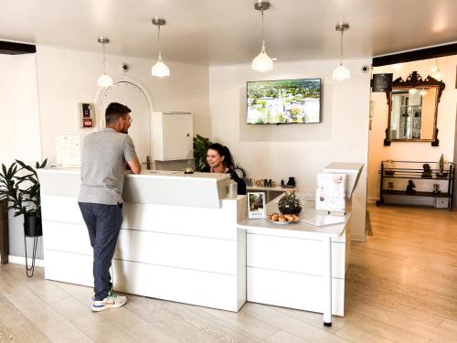 a man and a woman standing at a counter at Ostella Spa & Resort in Bastia