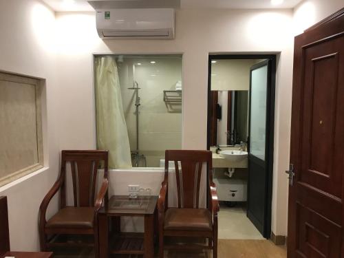 a bathroom with a table and two chairs and a tub at Victoria hotel in Ha Long