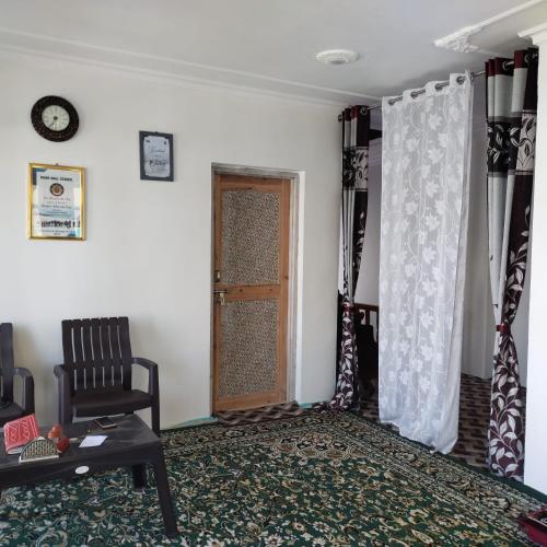 a living room with a door and a chair at Elizabeth paying guest house Tangmarg gulmarg in Gulmarg