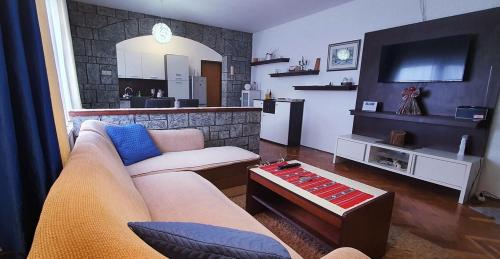 a living room with a couch and a tv at Apartman Ksenija in Đakovo