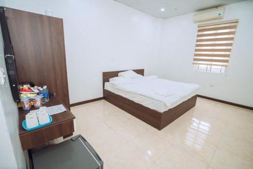 um quarto com uma cama e uma televisão em Dung Hà Hotel 