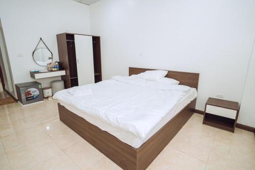um quarto com uma cama grande e lençóis brancos em Dung Hà Hotel 