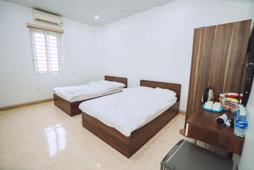 a bedroom with two beds and a television in it at Dung Hà Hotel 