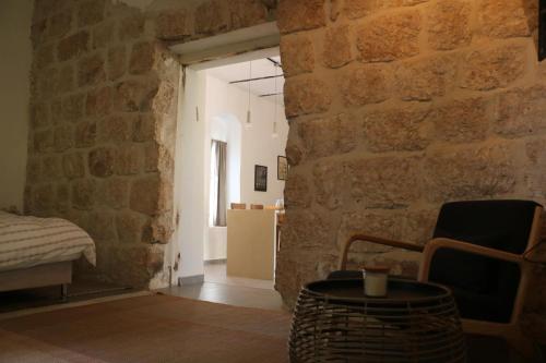 Pokój z kamienną ścianą z krzesłem i stołem w obiekcie The stone house w mieście Kefar Daniyyel