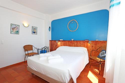 ein Schlafzimmer mit einem weißen Bett und einer blauen Wand in der Unterkunft Casa Le Ferreira in Praia da Luz in Luz
