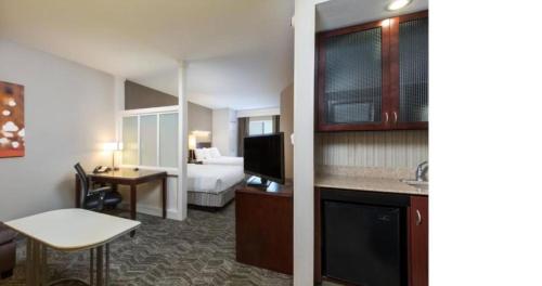 a hotel room with a bed and a kitchen at SpringHill Suites Indianapolis Fishers in Indianapolis