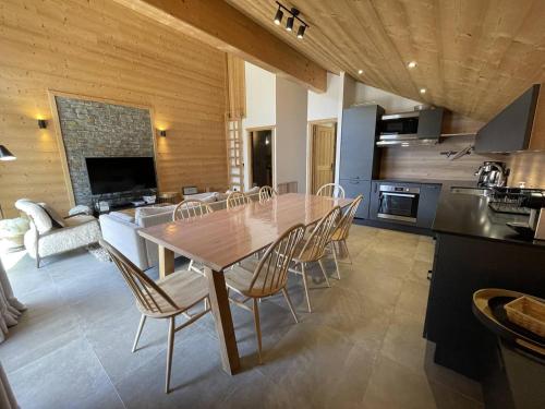 une cuisine et une salle à manger avec une table et des chaises en bois dans l'établissement Spacieux duplex pour 10 personnes avec terrasses en coeur de village - Aiguilles 203, à Saint-Sorlin-dʼArves