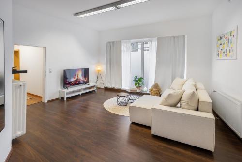 a living room with a white couch and a tv at ruhrApartments #Nähe A40 #zentral #fastWIFI #perfekt für Familien und Geschäftsreisen in Bochum