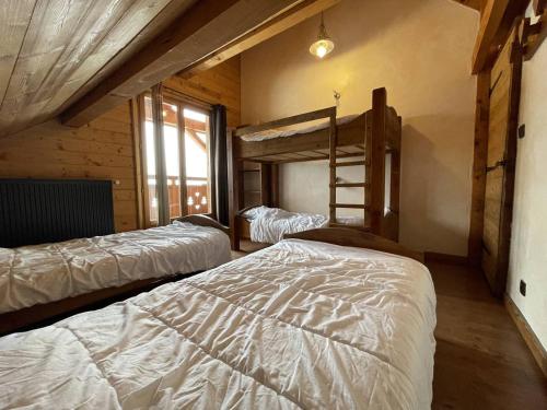 a bedroom with two bunk beds and a window at Chalet montagnard 15 personnes - proche du centre du village in Saint-Sorlin-dʼArves