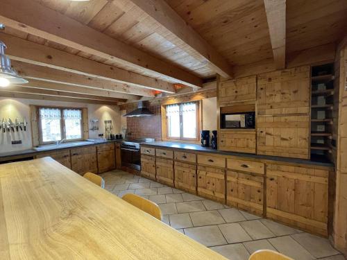une grande cuisine avec des placards en bois et une table en bois dans l'établissement Chalet montagnard 15 personnes - proche du centre du village, à Saint-Sorlin-dʼArves