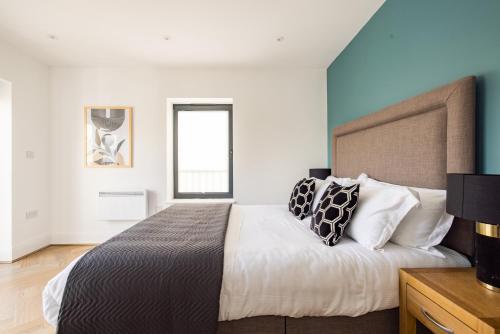 a bedroom with a large bed with two pillows at Charles Hope Staines Riverside in Staines