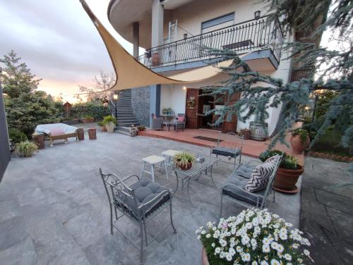 a patio with chairs and tables in front of a building at Casa degli Ulivi Etna in Ragalna