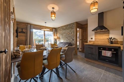 a kitchen and dining room with a table and chairs at Appartement neuf avec terrasse plein sud - 6 personnes in Saint-Sorlin-dʼArves